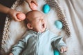 Cute baby Easter bunny. Little baby boy with bunny ears and Easter eggs in wicker basket in white fur. Symbol of Easter holiday, Royalty Free Stock Photo