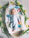 Cute baby Easter bunny. Little baby boy with bunny ears and Easter eggs in wicker basket in white fur. Symbol of Easter holiday, Royalty Free Stock Photo