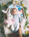 Cute baby Easter bunny. Little baby boy with bunny ears and Easter eggs in wicker basket in white fur. Symbol of Easter holiday, Royalty Free Stock Photo