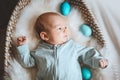 Cute baby Easter bunny. Little baby boy with bunny ears and Easter eggs in wicker basket in white fur. Symbol of Easter holiday, Royalty Free Stock Photo