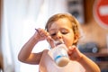 cute baby eating yogurt with spoon by himself. adorable toddler has lunch. hungry child. Royalty Free Stock Photo