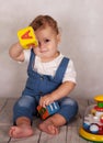 Lovely baby playing with blocks with letters and smiles Royalty Free Stock Photo