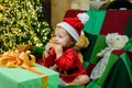 Cute baby face in Santa hat near Christmas tree. Happy Childhood, child 1 year old. New year kids. Christmas miracle Royalty Free Stock Photo