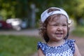 Cute baby girl in baseball cap, shine with happiness, curly hair, charming smile, sunny summer portrait. Royalty Free Stock Photo
