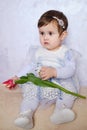 Cute Baby girl in blue dress holding tulip. Holiday card for mothers or fathers day greeting. Portrait Of A Beautiful Little Girl Royalty Free Stock Photo