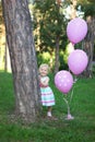 Cute baby girl in a colorful dress smiling in the park Royalty Free Stock Photo