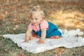 Cute baby girl crawling on ground in park outdoor. Child toddler exploring nature world around. Healthy physical development. Royalty Free Stock Photo