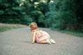 Cute baby girl crawling on road in park outdoor. Adorable child toddler exploring studying the world around. Healthy physical Royalty Free Stock Photo