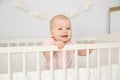 Cute baby girl in crib at home. Bedtime