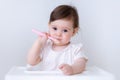 Cute Baby girl eating blend mashed food sitting, on high chair, mother feeding child, hand with spoon for vegetable Royalty Free Stock Photo