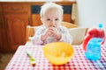 Cute baby girl eating lunch in the kitchen Royalty Free Stock Photo