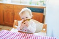 Cute baby girl eating pear in the kitchen Royalty Free Stock Photo