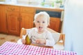 Cute baby girl eating pear in the kitchen Royalty Free Stock Photo