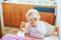 Cute baby girl eating pear in the kitchen Royalty Free Stock Photo