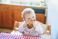 Cute baby girl eating pear in the kitchen Royalty Free Stock Photo