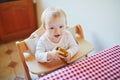 Cute baby girl eating pear in the kitchen Royalty Free Stock Photo