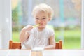 Cute baby girl eating yogurt from spoon Royalty Free Stock Photo