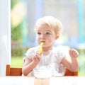 Cute baby girl eating yogurt from spoon Royalty Free Stock Photo