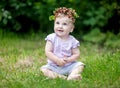 Cute baby girl with gold hair and wild strawberry crown Royalty Free Stock Photo