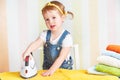 Cute baby girl housewife iron clothes iron, is engaged in domes Royalty Free Stock Photo