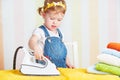 Cute baby girl housewife iron clothes iron, is engaged in domes Royalty Free Stock Photo