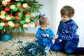 Cute baby girl and kid boy taking down holiday decorations from Christmas tree. children, siblings, brother and sister Royalty Free Stock Photo