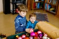 Cute baby girl and kid boy taking down holiday decorations from Christmas tree. children, siblings, brother and sister Royalty Free Stock Photo