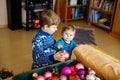 Cute baby girl and kid boy taking down holiday decorations from Christmas tree. children, siblings, brother and sister Royalty Free Stock Photo