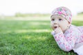 Cute baby girl looking up while lying down on grass in park Royalty Free Stock Photo