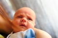 Cute baby girl makes a funny upset face on mothers hand Royalty Free Stock Photo