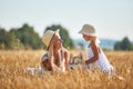 Cute baby girl with mom and dog on wheat field. Happy young family enjoy time together at the nature. Mom, little baby Royalty Free Stock Photo