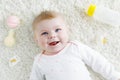 Cute baby girl playing with colorful pastel rattle toy, nursing bottle and dummy Royalty Free Stock Photo