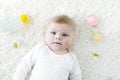 Cute baby girl playing with colorful pastel rattle toy, nursing bottle and dummy Royalty Free Stock Photo