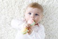 Cute baby girl playing with colorful pastel vintage rattle toy Royalty Free Stock Photo