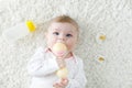 Cute baby girl playing with colorful pastel vintage rattle toy Royalty Free Stock Photo