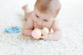 Cute baby girl playing with colorful pastel vintage rattle toy Royalty Free Stock Photo