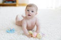 Cute baby girl playing with colorful pastel vintage rattle toy Royalty Free Stock Photo