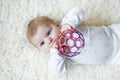 Cute baby girl playing with colorful rattle ball toy Royalty Free Stock Photo