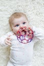 Cute baby girl playing with colorful rattle toy Royalty Free Stock Photo