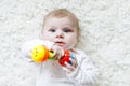 Cute baby girl playing with colorful rattle toy Royalty Free Stock Photo