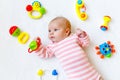 Cute baby girl playing with colorful rattle toys Royalty Free Stock Photo
