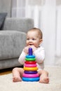 Cute baby girl playing with colorful toy pyramid Royalty Free Stock Photo