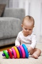 Cute baby girl playing with colorful toy pyramid Royalty Free Stock Photo