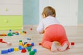 Cute baby girl playing with educational toys. Happy healthy child having fun with colorful different wooden blocks at Royalty Free Stock Photo