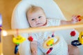 Cute baby girl playing with hanging wooden rattle toys Royalty Free Stock Photo