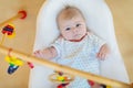 Cute baby girl playing with hanging wooden rattle toys Royalty Free Stock Photo