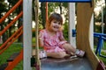 Cute baby girl Playing At Playground In Summer Sunny Day. Little girl licking chupa chups