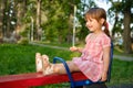 Cute baby girl Playing At Playground In Summer Sunny Day. Little girl licking chupa chups