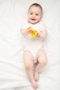 Cute baby girl playing with rattle on bed Royalty Free Stock Photo