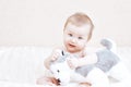 Cute baby girl playing with soft toy on bed in bedroom Royalty Free Stock Photo